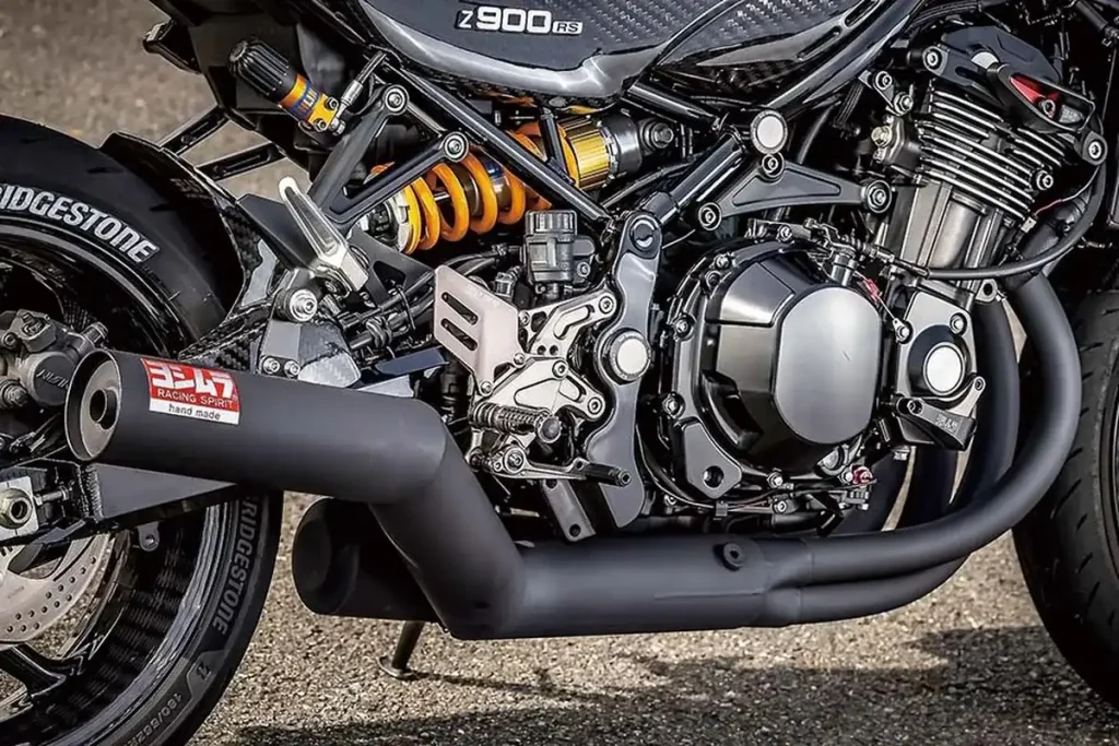 排氣系統採用 4-2-1 的配置,並搭載經消光黑處理的「YOSHIMURA Straight Cyclone Duplex Shooter」。照片中的「手工彎管 Straight Cyclone Duplex Shooter 全段排氣管 Z900RS / CAFE (18-)」,前段+集合段採用鋼材手工彎管加工,並在集合段之後使用不鏽鋼材質。而「機械彎管 Straight Cyclone Duplex Shooter 全段排氣管 (JMCA認證) Z900RS / CAFE (18-24)」,則為全段不鏽鋼材質。