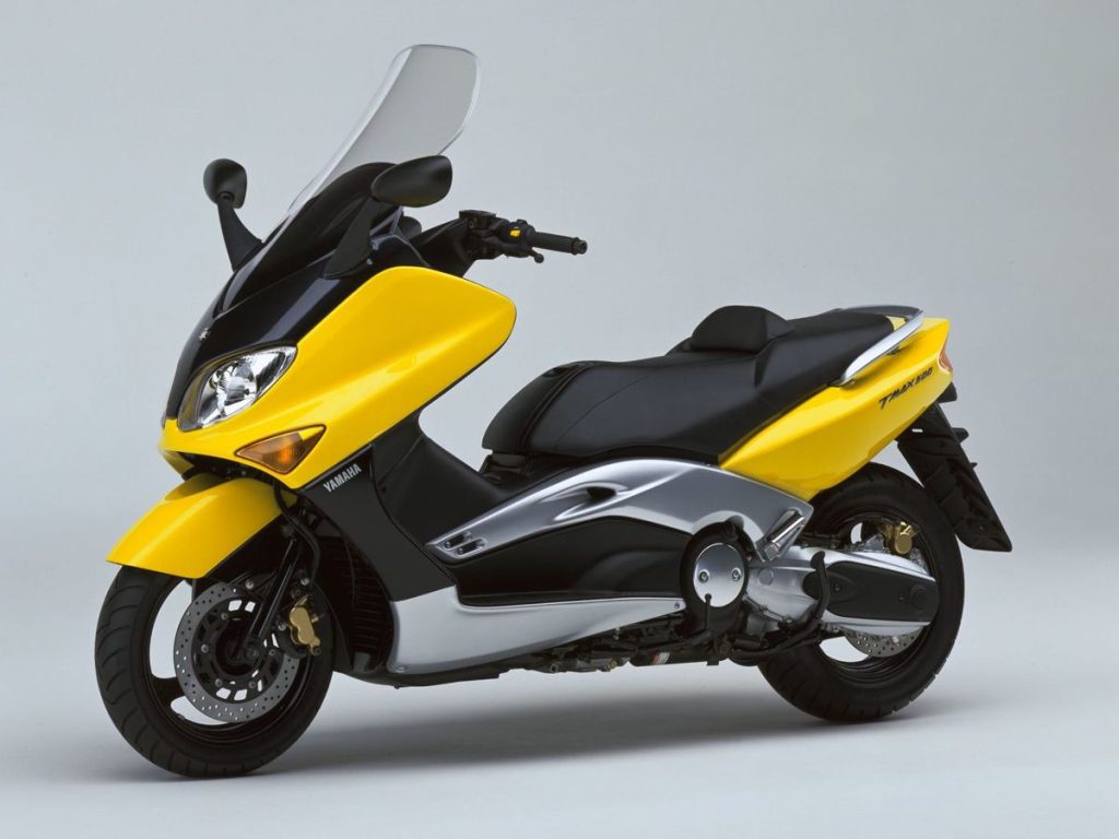 2001 年推出的首代 TMAX,搭載 530cc 並列雙缸引擎,採用獨特的活塞式平衡機構與鋁合金車架。這樣的配置一路沿用至今日,排氣量提升至 560cc。