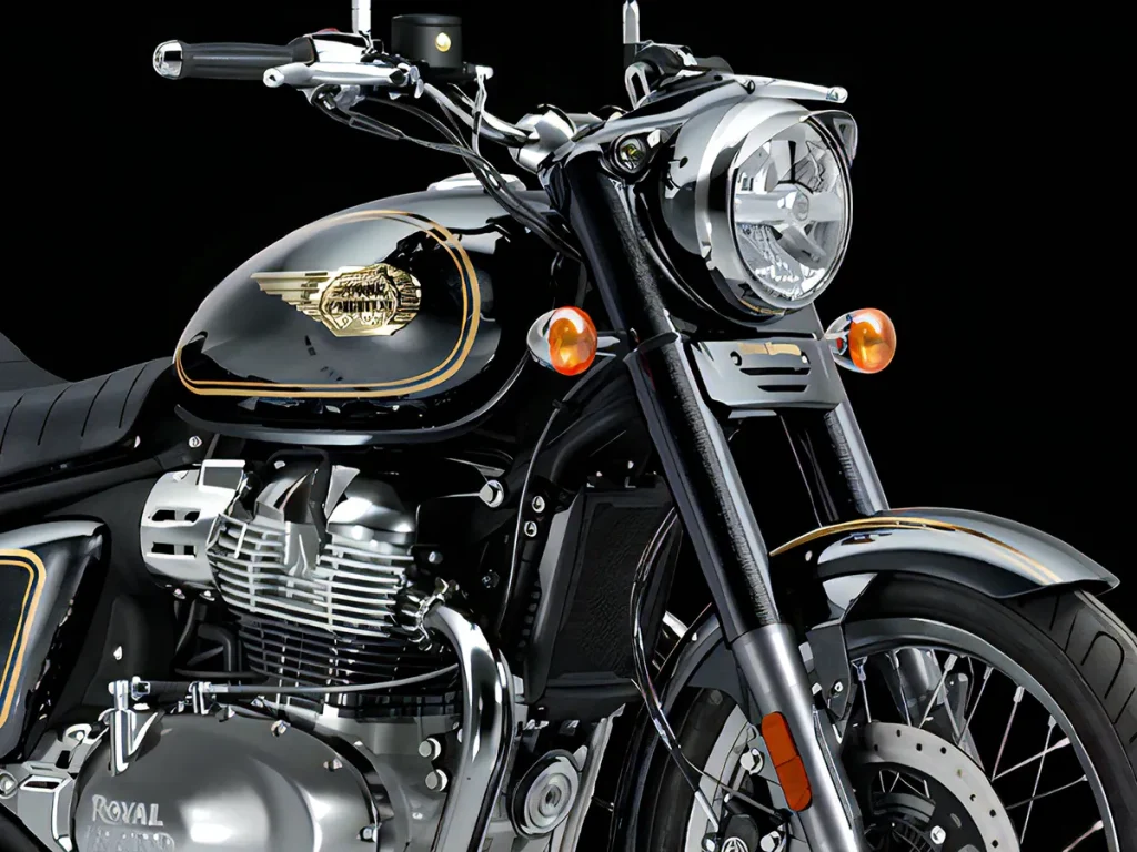 油箱上带有手绘金色线条与 3D 立体飞翼徽章,细节质感浓厚。头灯则延续 Royal Enfield 传统的“Tiger Eye”小灯设计。