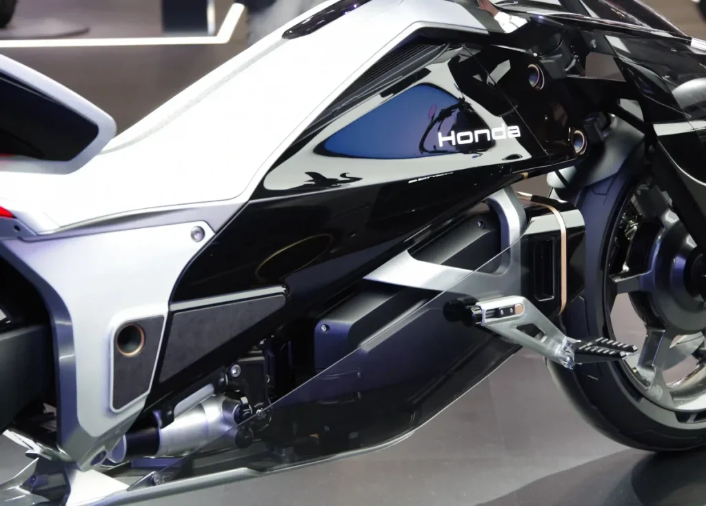 帶有 Honda 標誌的黑色區塊為電池，電池下方是控制系統與電子模組。電池與控制單元分離設計為其特色之一。前輪後方配置了電池冷卻用散熱器。