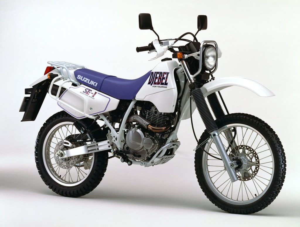 1992 年推出的初代DJEBEL 250，搭载可输出 29ps马力的 249cc 油冷单缸引擎，齿比设定也更适合林道使用。“DJEBEL”在阿拉伯语中意指山脉、丘陵或小山。