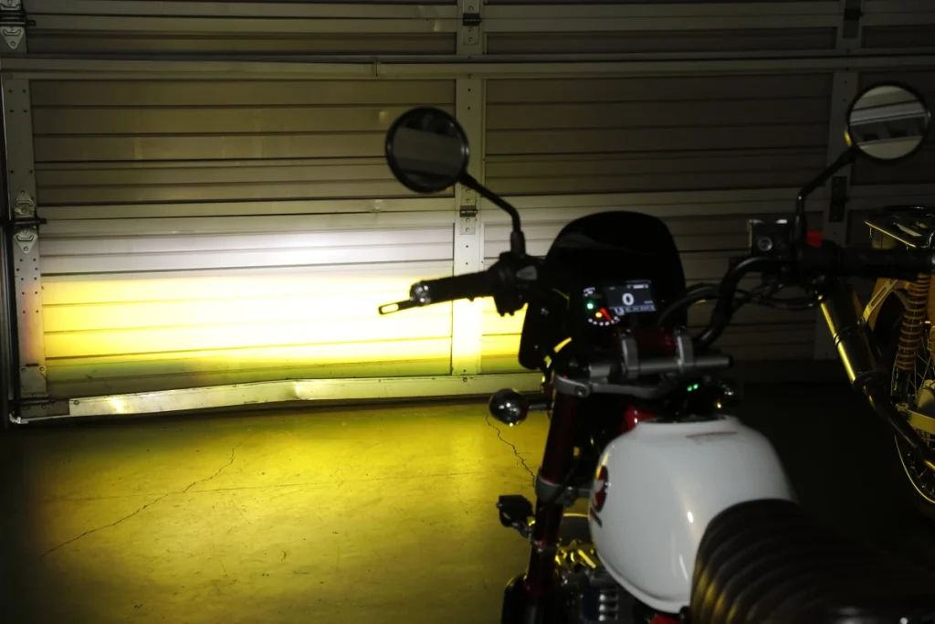 ● 切換至黃光時，光軸會稍微下降，加強車輛前方路面照明，提升雨濃霧天的視認性。黃光光束上方微弱的光線即是原廠頭燈，兩者亮度差距顯著。