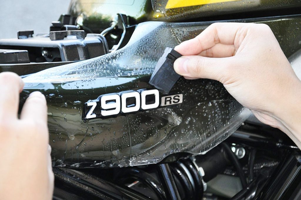 依照說明書先固定廠徽周邊,再向外擴散,但往往顧好一處另一處可能又翹起,難度相當高。