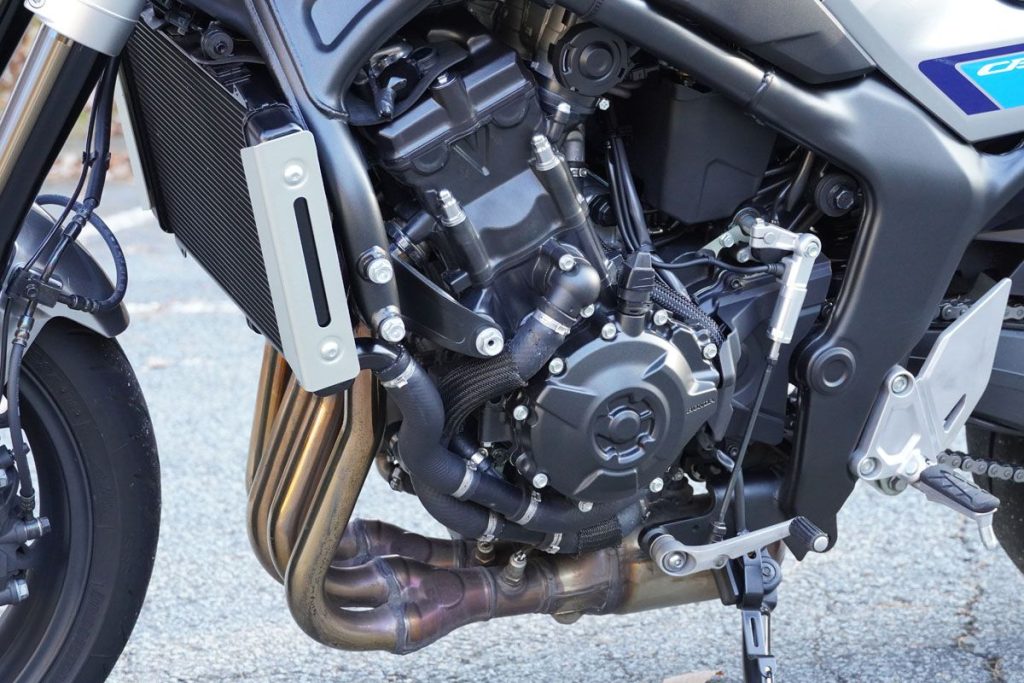 F 透過相位凸輪、左右氣缸異徑的進氣喇叭口及排氣管內部構造進行調校。電控方面也比 Hornet 多了 6 軸 IMU，強化了循跡控制（Traction Control）精度。