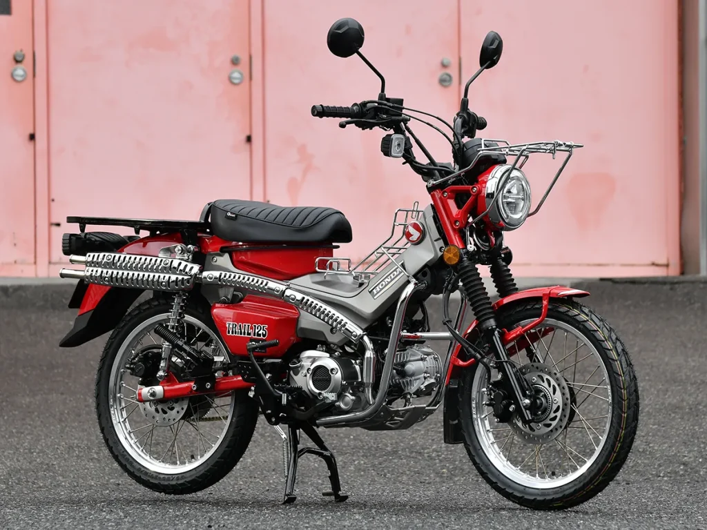 以紅色車身為基礎,搭配灰色的車架中央護蓋,大幅改變了原有的視覺印象。 安裝了後貨架與側箱來提升載物能力,打造成一台從日常代步到長途旅行都非常便利的車款